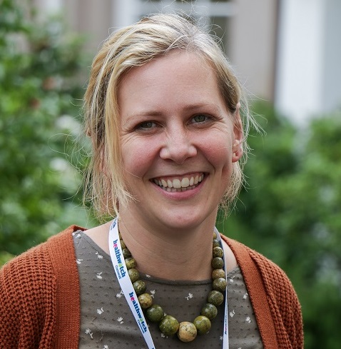 Woman outside an office with a lanyard, healthwatch safeguarding officer