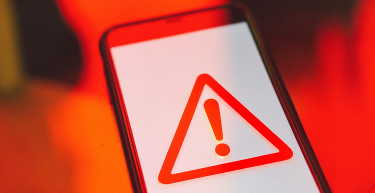 Image of a mobile phone with a triangle warning symbol on the screen
