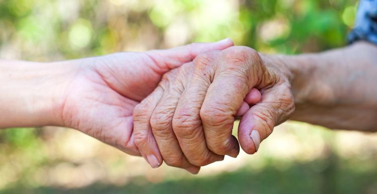 Elderly hands being held