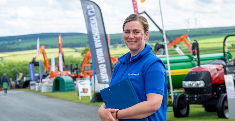 Woman in Healthwatch Cornwall clothes in front of a tractor