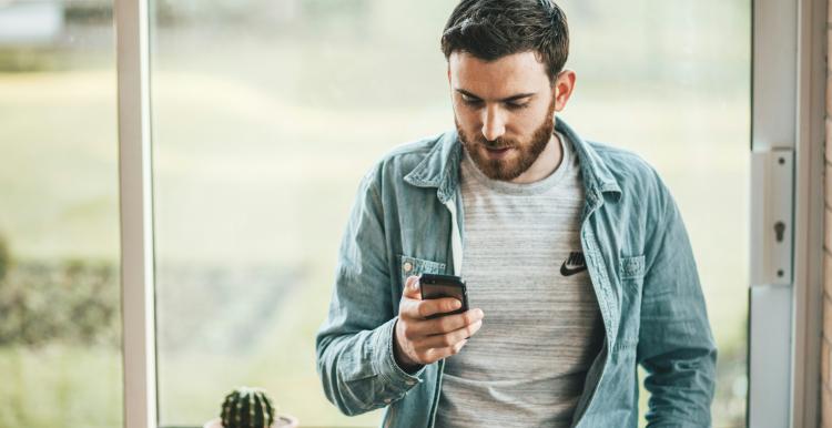 Man looking at his phone at home