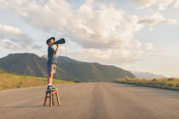 a boy on a stool with a microphone.