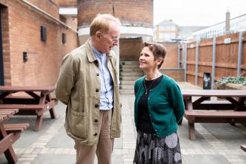 An older couple smiling and talking to each other