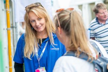 Woman from Healthwatch Cornwall smiling while speaking to another woman