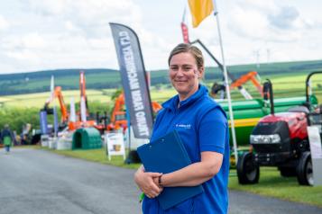 Woman in Healthwatch Cornwall clothes in front of a tractor