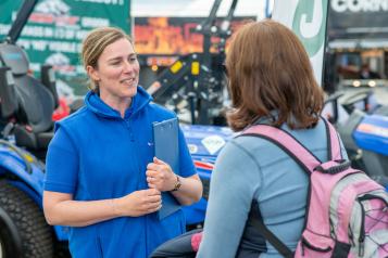 Woman from Healthwatch Cornwall with a clipboard speaking to another woman