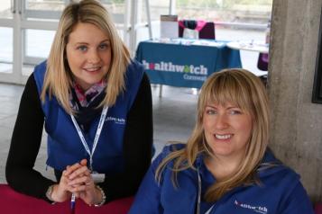 Two women from Healthwatch Cornwall smiling at an event
