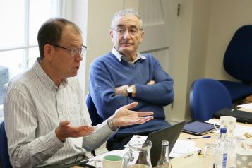 Three people having a discussion at a board meeting