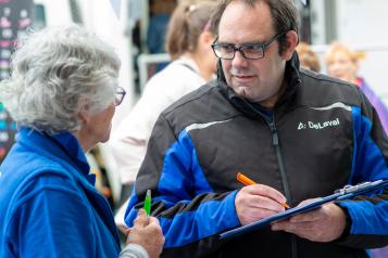 Woman from Healthwatch Cornwall having a conversation with a man filling in a form