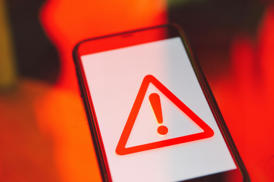 Image of a mobile phone with a triangle warning symbol on the screen 