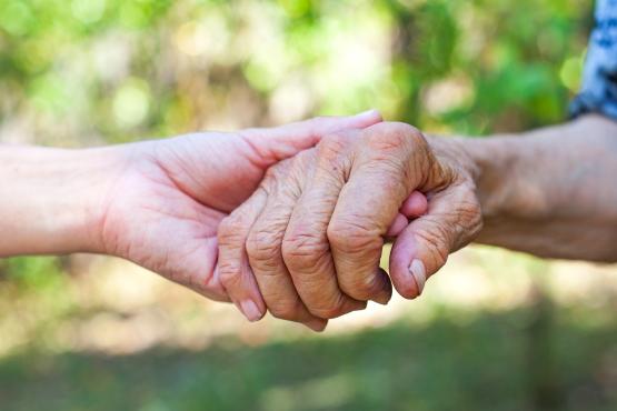 Elderly hands being held