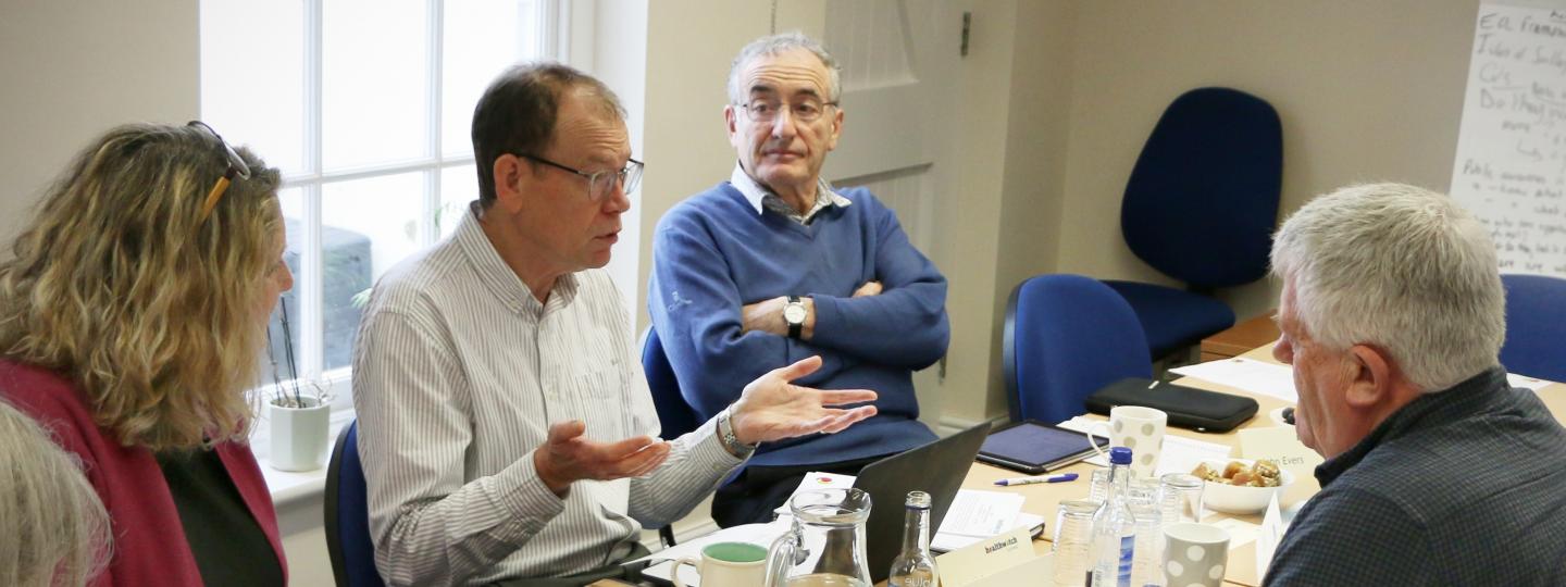 Three people having a discussion at a board meeting